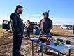 Two persons talking at a display table during a field day.